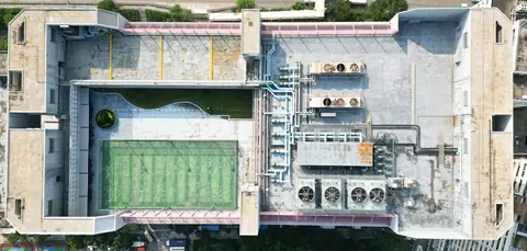 屯門吉田大廈屋頂垂直航拍,可見綠色球場、多組機電設備及管道