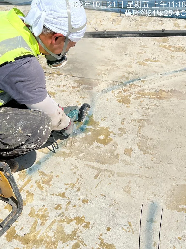 薄扶林道碧瑤灣工程:工人以手提電動工具處理斑駁天台表面