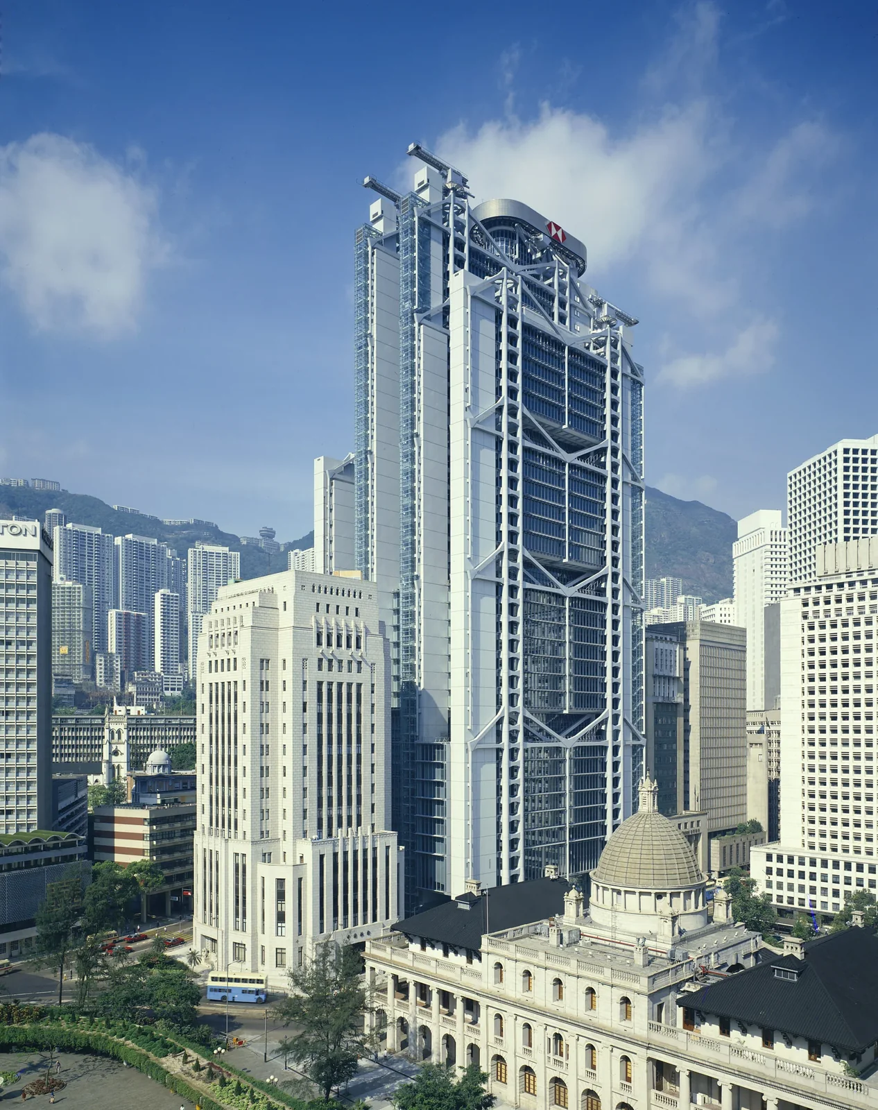 香港中環匯豐總行大廈外觀,周圍可見市區樓宇與山景