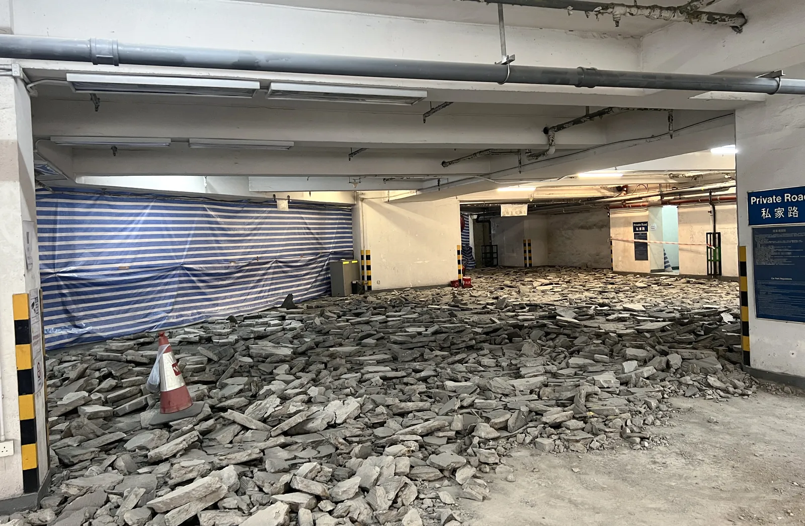 炮台山理文商業中心停車場地面鋪滿破碎混凝土塊,旁邊有雪糕筒與圍封布