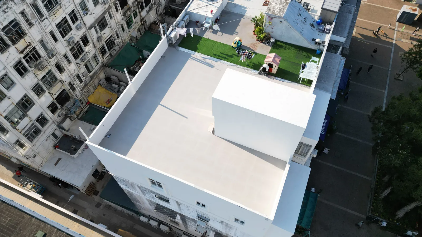 高空俯瞰西貢灣景街白色平屋面和中央天台構築物，旁邊設有人造草地