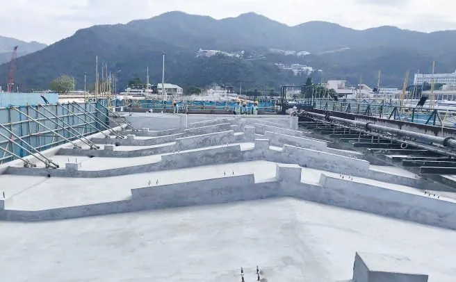 沙田馬場馬廄屋面排列多道淺灰色凸起分隔牆,旁邊設有大型管道
