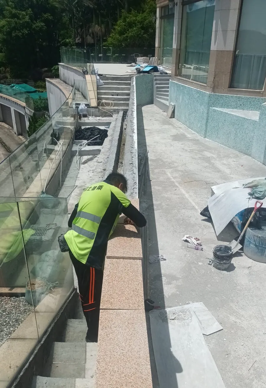 銀線灣銀臺路工程:工人在玻璃欄河旁處理狹窄露台邊位